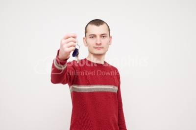 One young man caucasian holding keys portrait in studio white ba