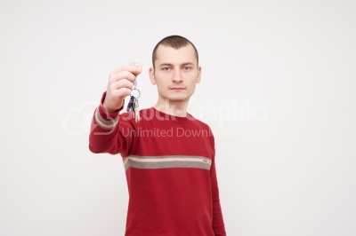 One young man caucasian holding keys portrait in studio white ba