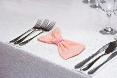 Pink bow between silver cutlery