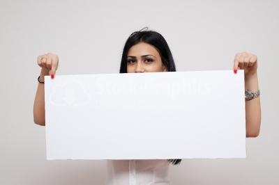 Pretty brunette woman posing behind a white panel isolated on wh
