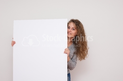 Pretty woman posing behind a white panel isolated on white backg