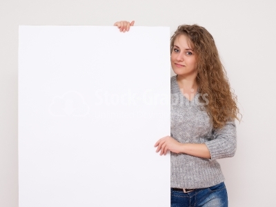 Pretty woman posing behind a white panel isolated on white backg