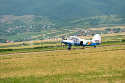 Propeller plane on field near the mountains