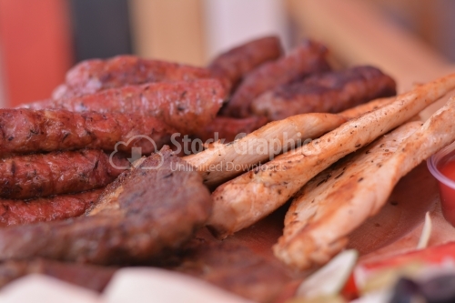 Sausages and grilled chicken breast close up.