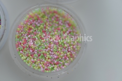 Small Glass Jars filled with Multicolored Balls of Bead