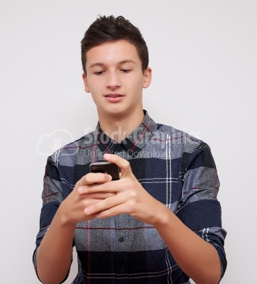Smiling young man loves his smartphone - Stock Image