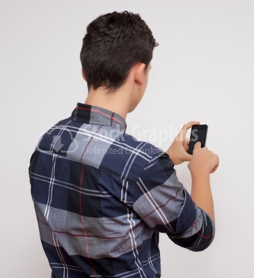 Smiling young man loves his smartphone - Stock Image