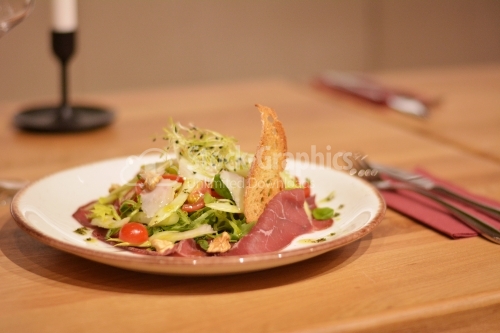 Spanish ham with green salad, tomato and wheat grains.