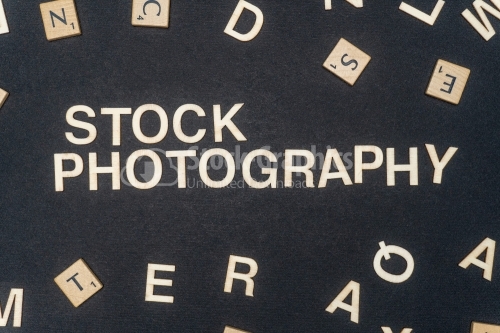 STOCK PHOTOGRAPHY word written on dark paper background. STOCK PHOTOGRAPHY text for your concepts