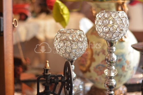 Two candlesticks with precious stones on the shelf of a shop.
