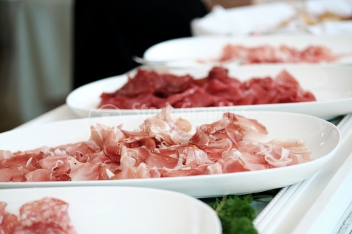 White plates with different kinds of ham. Prosciutto.