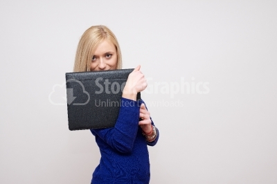 Woman covering his mouth with a black notebook