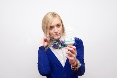 Young blonde girl looking at a light bulb
