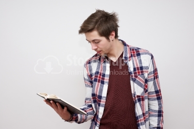 Young guy reading from a small note book