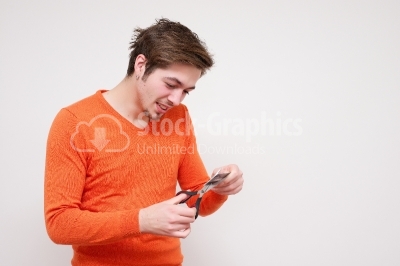 Young man cutting a credit card