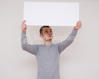 Young man holding a white panel above his head isolated on white