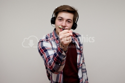 Young man in headphones holding jackplug in his hand isolated on
