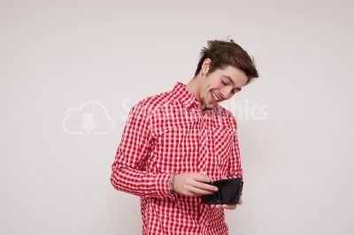 Young man laughing at his empty wallet