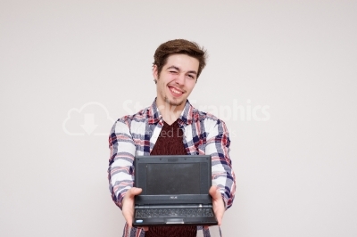 Young man presenting his old laptop