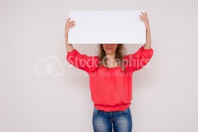 Young woman holding a white panel above her head isolated on whi